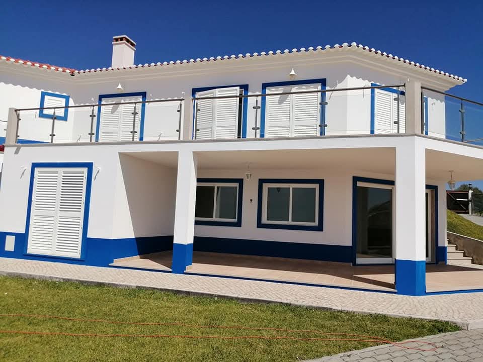 Moradia com fachada branca e azul após pintura